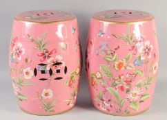 A PAIR OF PINK PORCELAIN BARREL SEATS painted with flowers and insects. 1ft 6ins high.