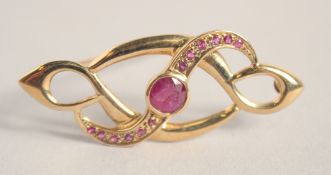 A 9CT GOLD RUBY SET BROOCH.