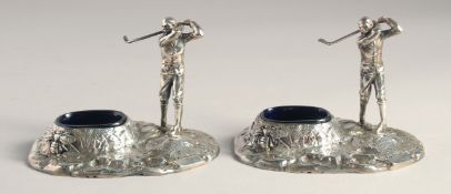 A PAIR OF SILVER PLATED GOLFER SALTS with blue liners.