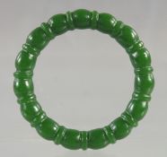 A RIBBED GREEN JADE BANGLE. 2.75ins diameter.