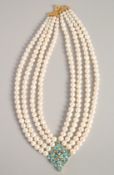 A FOUR STRAND PEARL NECKLACE with blue topaz clasp.
