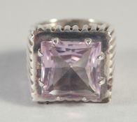 A LARGE SILVER AND AMETHYST SQUARE RING.