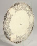 A GOOD PIERCED SILVER CIRCULAR COMPORT decorated with fruiting vines. 12ins diameter. Sheffied 1946,