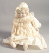 A PORCELAIN HEADED BABY DOLL. 14ins long.