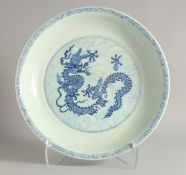 A CHINESE BLUE AND WHITE PORCELAIN CHARGER with central dragon on stylised waves and further