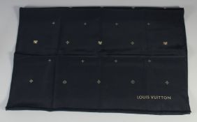 A LOUIS VUITTON BLACK SILK SCARF with gold emblems. 120cm x 120cm.