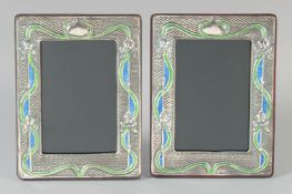 A PAIR OF ART NOUVEAU SILVER AND ENAMEL PHOTOGRAPH FRAMES. 7.5ins x 5.75ins