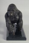 A BRONZE STANDING GORILLA on a marble base.