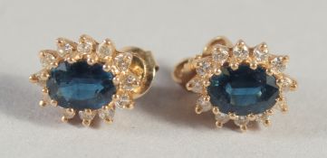 A PAIR OF YELLOW GOLD SAPPHIRE AND DIAMOND CLUSTER EARRINGS.