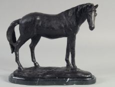 A BRONZE STANDING HORSE on a shaped marble base. 8ins high.