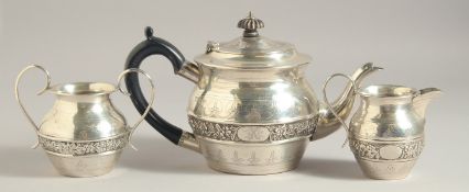 AN EDWARD VII ART NOVEAU DESIGN THREE PIECE TEA SET with a girdle of flowers. London 1906. Weight:
