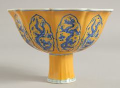 A CHINESE YELLOW GROUND BLUE AND WHITE PORCELAIN STEM CUP, decorated with panels of dragons. Bowl