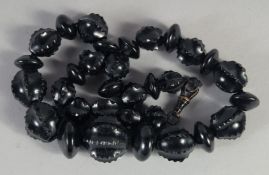A SMALL CARVED JET GRADUATED BEAD NECKLACE. 16ins long, 42gms.