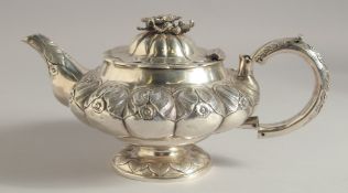 A GEORGE IV SILVER CIRCULAR TEA POT AND COVER with flower knop and C scroll handle. London 1820.