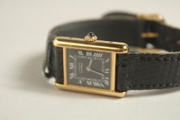 A LADIES CARTIER SILVER GILT .925 ARGENT WRIST WATCH with leather strap. No. 1490087, in a Carier