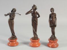 A SET OF THREE BRONZE ART NOUVEAU GIRLS on a circular marble base.