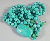 A STRING OF OVER ONE HUNDRED TURQUOISE BEADS and pendant. 33ins long.