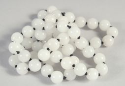 A STRING OF SIXTY WHITE JADE BEADS. 28ins long.