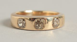 A GENTLEMAN'S GOLD THREE STONE RING.