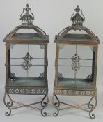 A PAIR OF METAL RECTANGULAR LANTERNS on stands. 28ins high.