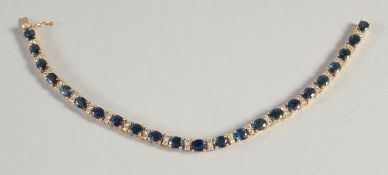 AN 18CT YELLOW GOLD DIAMOND AND SAPPHIRE LINE BRACELET.