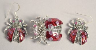 A SILVER ENAMEL RUBY SET LADYBIRD EARRINGS AND BROOCH.