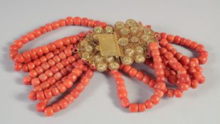 A GOLD ISLAMIC FIVE ROW CORAL NECKLACE with long gold filigree clasp.