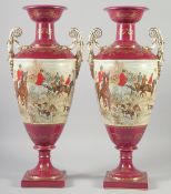 A LARGE PAIR OF CONTINENTAL BURGUNDY TWO HANDLED VASES with hunting scenes. 19ins high.