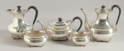 A GOOD FIVE PIECE SILVER TEA SET with a shell and garland rim on claw feet, comprising: tea pot,