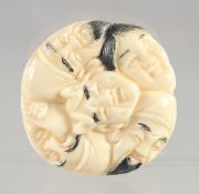A CHINESE CARVED BONE FACES NETSUKE. 1.5ins