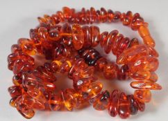 A GOOD GRADUATED AMBER BEAD NECKLACE, 100 beads, 26ins long, 89gms.