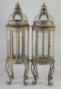 A PAIR OF CIRCULAR LANTERNS on curving legs. 2ft 8ins high.