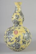 A CHINESE YELLOW GROUND PORCELAIN DOUBLE GOURD VASE, with floral decoration and characters in red,