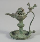 A 13TH CENTURY PERSIAN SELJUK BRONZE OIL LAMP, the handle with a bird finial, 12.5cm high.