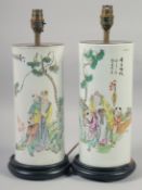 A PAIR OF CHINESE FAMILLE ROSE CYLINDRICAL PORCELAIN LAMP VASES, mounted to hardwood stands, each