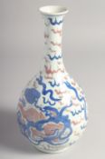 A CHINESE BLUE AND UNDERGLAZE RED PORCELAIN BOTTLE VASE, painted with foo dogs, 23.5cm high.