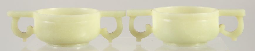 A PAIR OF CHINESE CARVED JADE TWIN HANDLE CUPS, 12cm wide (handle to handle).