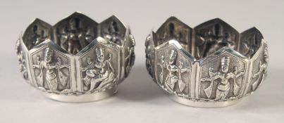 A PAIR OF INDIAN EMBOSSED SILVER BOWLS, with relief panels of figures / deities, combined weight