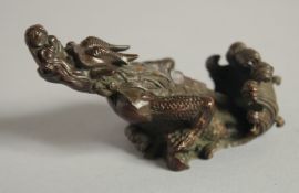 A JAPANESE BRONZE OKIMONO of a mythical beast, with six-character mark to base, 8.5cm long.
