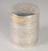 A FINELY ENGRAVED MALAY SILVER CYLINDER BOX; gifted by the sultan of Brunei, with gold plaque,