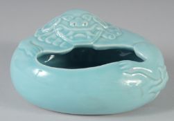 A CHINESE CLAIRE-DE-LUNE OVAL SECTION PORCELAIN BRUSHWASHER, moulded in relief with a Buddhistic