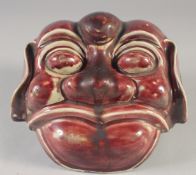 A CHINESE COPPER RED GLAZED POTTERY LION DOG MASK / WALL HANGING, 21cm wide.