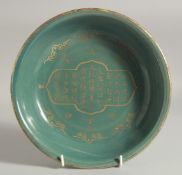 A CHINESE CELADON GLAZE BOWL, with incised gilt characters, 23.5cm diameter.