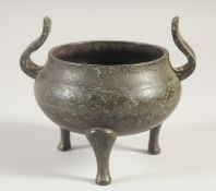 AN EARLY CHINESE BRONZE TWIN HANDLE TRIPOD CENSER, 13cm wide (handle to handle).