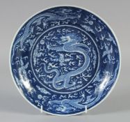A CHINESE BLUE AND WHITE PORCELAIN DRAGON DISH, six-character mark to base, 24cm diameter.