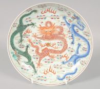 A CHINESE FAMILLE ROSE PORCELAIN PLATE, painted with dragons in coral red, blue and green, the
