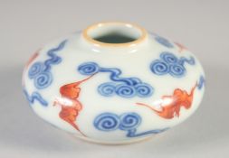 A CHINESE COPPER RED, BLUE AND WHITE PORCELAIN INKWELL, with bats and stylised clouds, 6.5cm