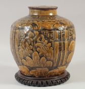 A CHINESE EARTHENWARE JAR AND COVER, with a carved hardwood stand, jar and cover, 25cm high.