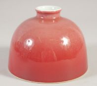 A CHINESE PEACH GLAZE PORCELAIN INK POT, with fitted box, 11cm diameter.