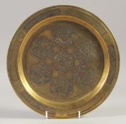 AN ISLAMIC SILVER AND COPPER INLAID BRASS DISH, 20.5cm diameter.